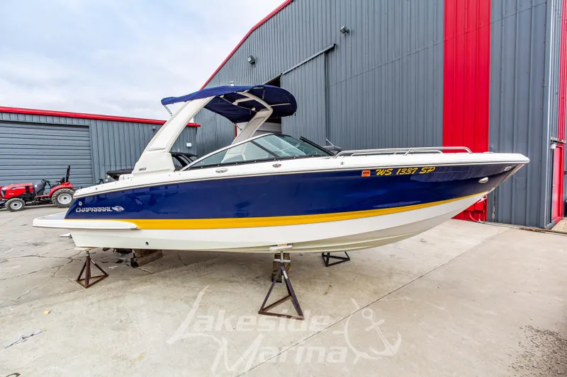 The Image of 2021 Chaparral 267 SSX boat in blue and white, displayed at a marina. - 1