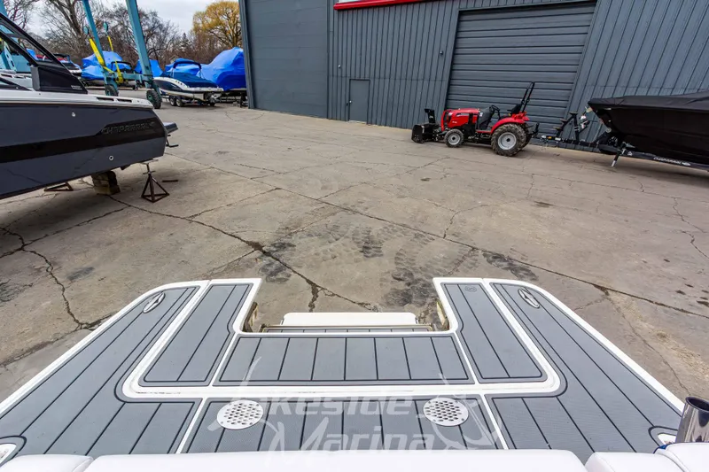 Slide: The Image of 2021 Chaparral 267 SSX boat at marina with tractor and covered boats in background. - 11