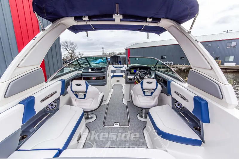 Slide: The Image of 2021 Chaparral 267 SSX boat interior with blue and white seating, modern dashboard. - 14