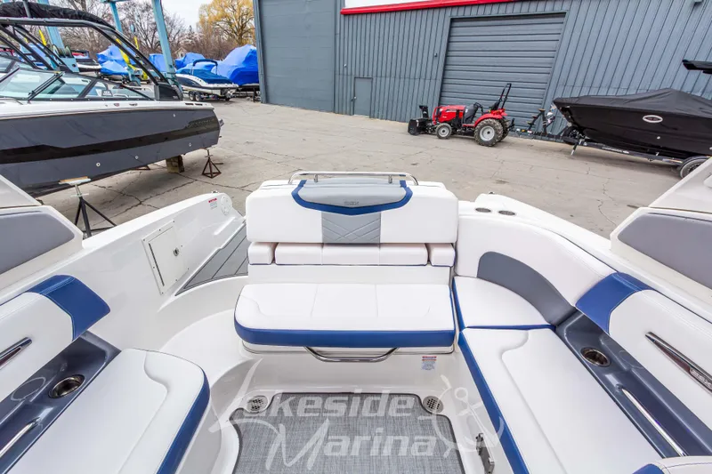 Slide: The Image of 2021 Chaparral 267 SSX boat interior with blue and white seating at marina. - 15