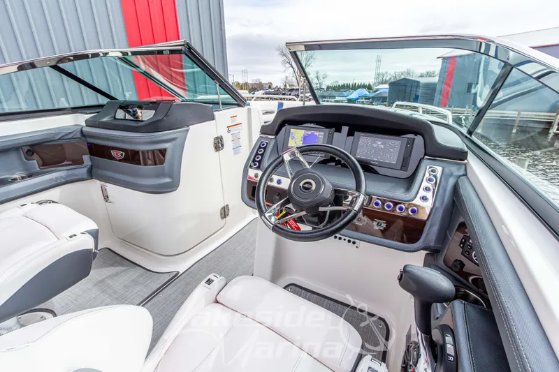 Slide: The Image of 2021 Chaparral 267 SSX boat cockpit with modern dashboard and steering wheel. - 19