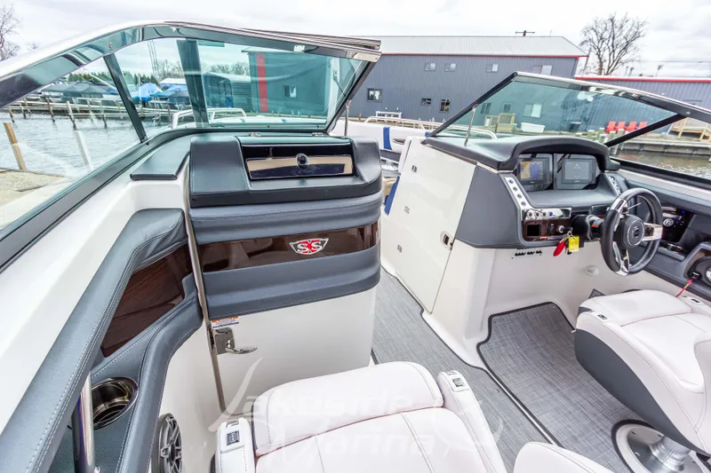 Slide: The Image of Interior view of a 2021 Chaparral 267 SSX boat, featuring modern dashboard and seating. - 25