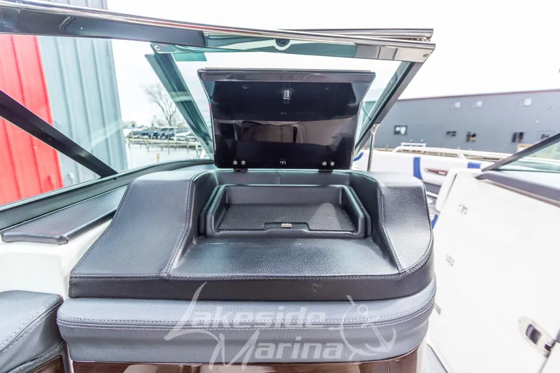 Slide: The Image of 2021 Chaparral 267 SSX boat dashboard with open storage compartment. - 26