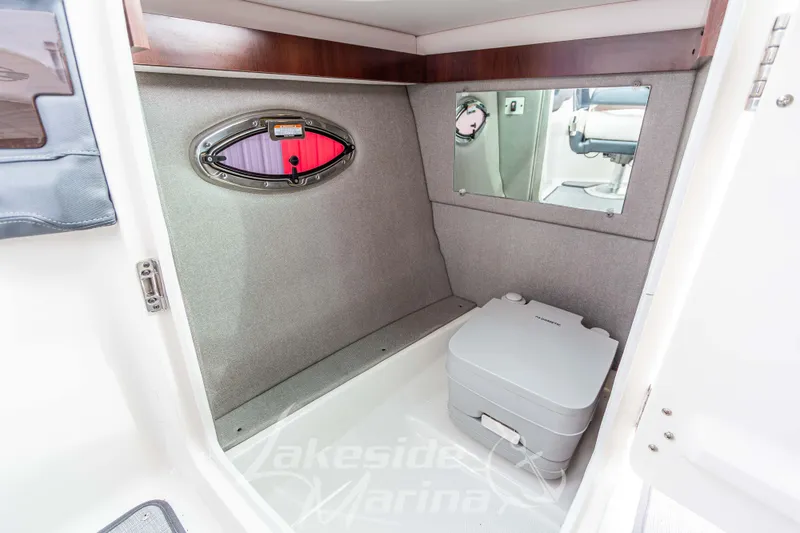 Slide: The Image of 2021 Chaparral 267 SSX boat interior with portable toilet and window. - 27