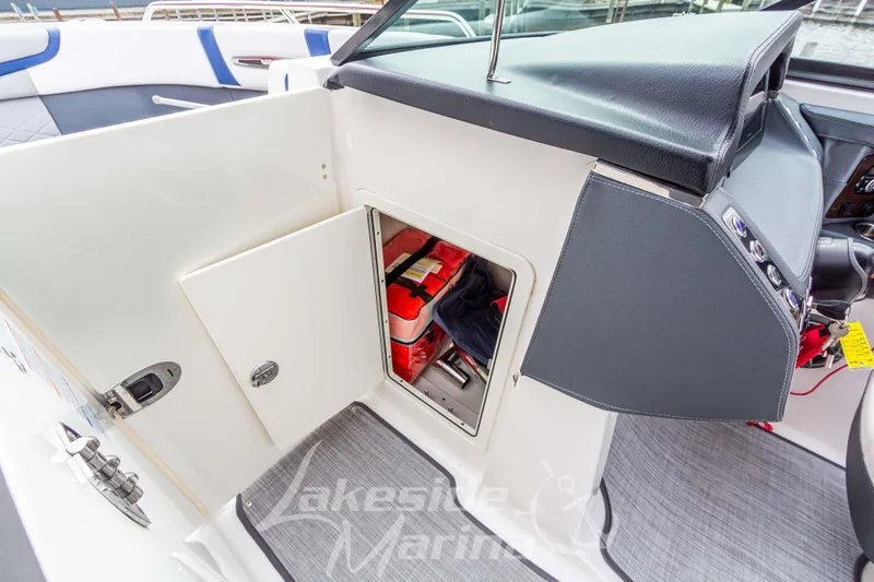 Slide: The Image of 2021 Chaparral 267 SSX boat interior with open storage compartment and visible safety equipment. - 29