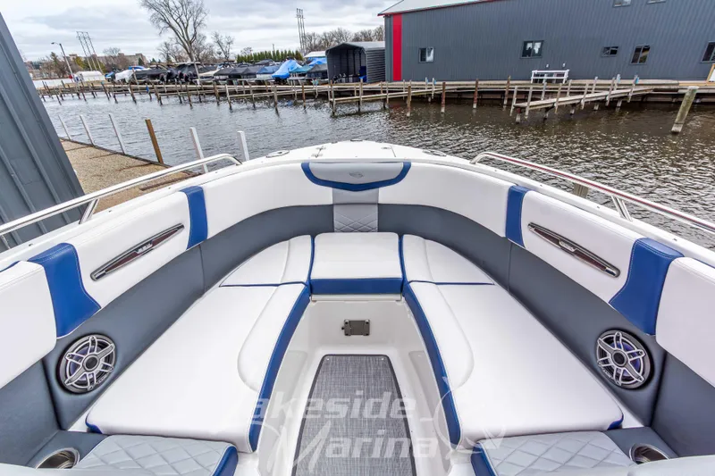 Slide: The Image of 2021 Chaparral 267 SSX boat interior with white and blue seating, dockside view. - 31