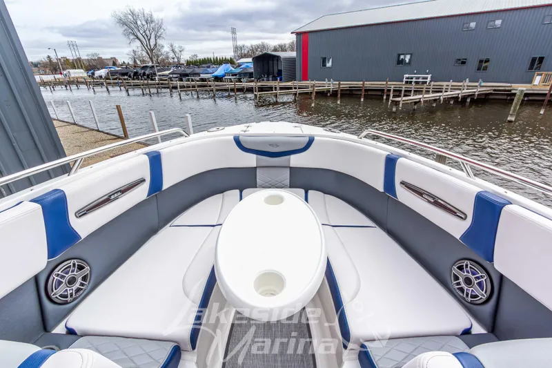 Slide: The Image of 2021 Chaparral 267 SSX boat interior with white and blue seating, dockside view. - 34