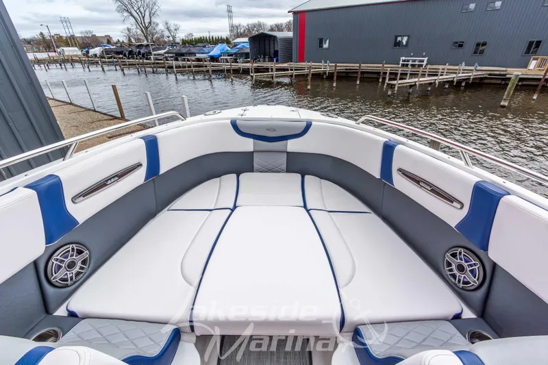 Slide: The Image of 2021 Chaparral 267 SSX boat interior with white and blue seating, dockside view. - 35