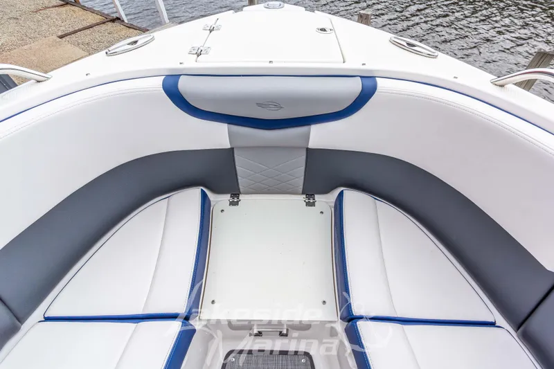 Slide: The Image of 2021 Chaparral 267 SSX boat interior with white and blue seating by the water. - 37