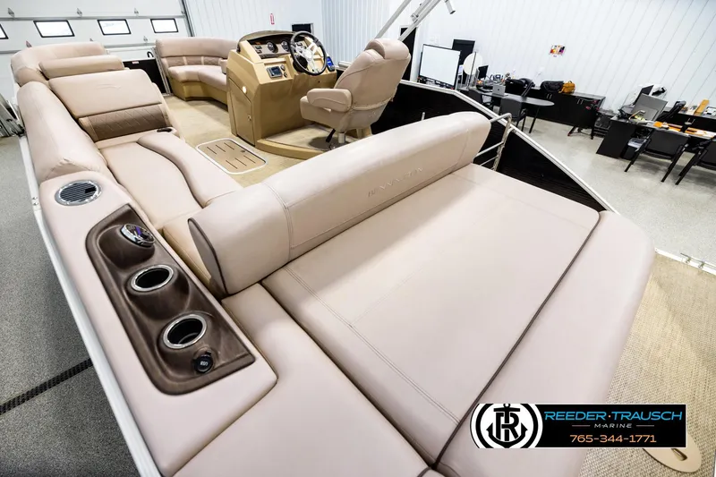 Slide: The Image of 2018 Bennington 24 SSBXPDL pontoon boat interior with beige seating and helm in showroom. - 11