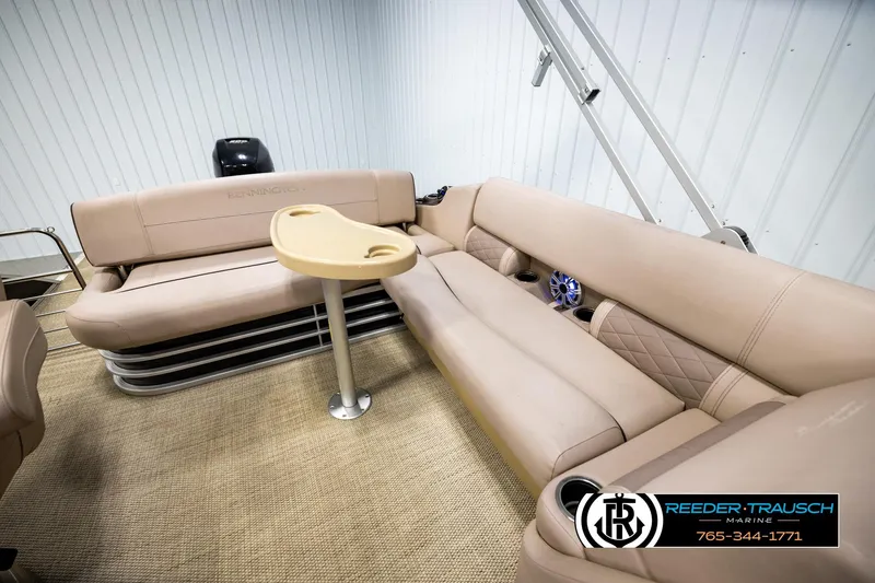 Slide: The Image of 2018 Bennington 24 SSBXPDL pontoon boat interior with beige seating and table. - 23