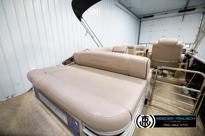 Slide: The Image of 2018 Bennington 24 SSBXPDL pontoon boat interior with beige seating in a showroom. - 27