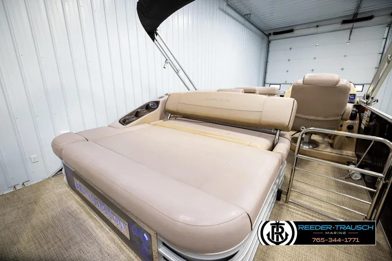 Slide: The Image of 2018 Bennington 24 SSBXPDL pontoon boat interior with beige seating in a garage. - 28