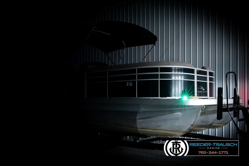 Slide: The Image of 2018 Bennington 24 SSBXPDL pontoon boat in a dimly lit storage area. - 4