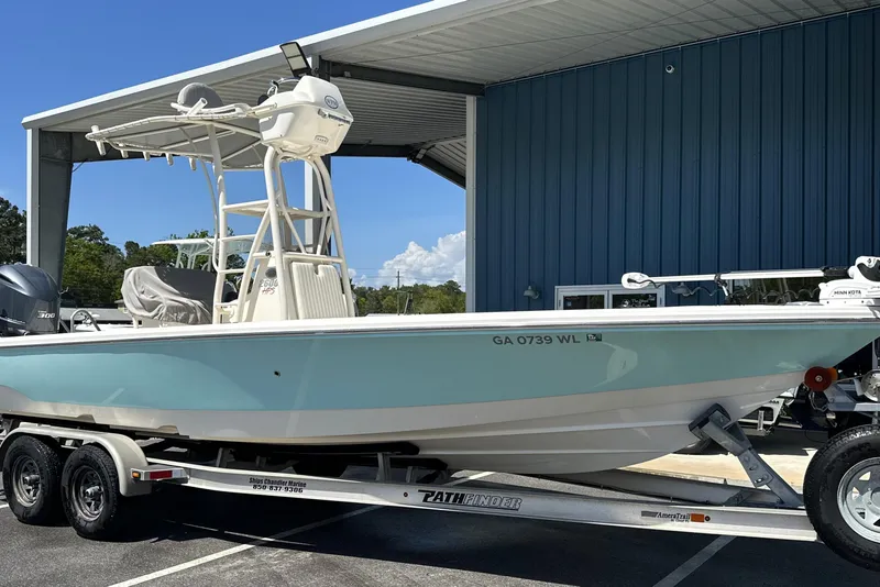 The Image of 2014 Pathfinder 2600 HPS boat on trailer, parked outside a blue building. - 0