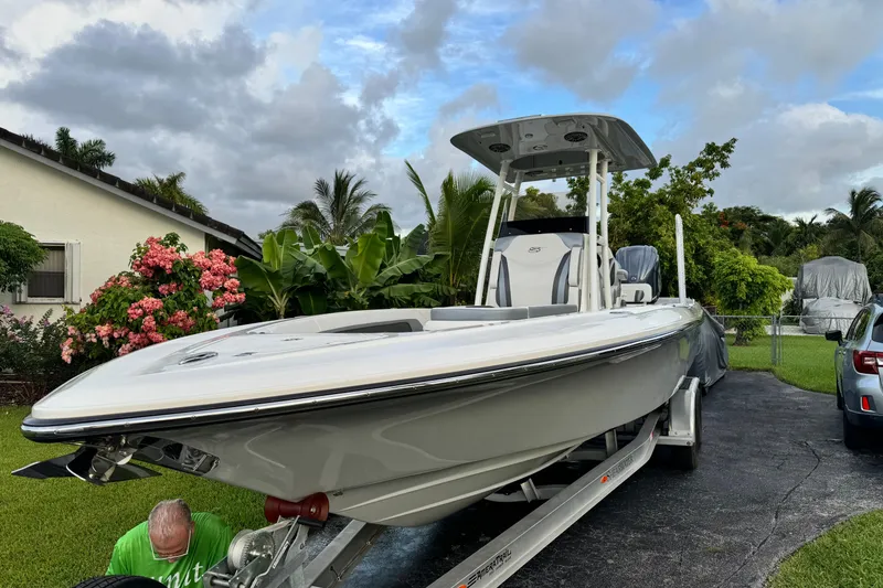 Slide: The Image of 2023 ShearWater 270 Carolina Flare boat on trailer in a tropical driveway setting. - 26