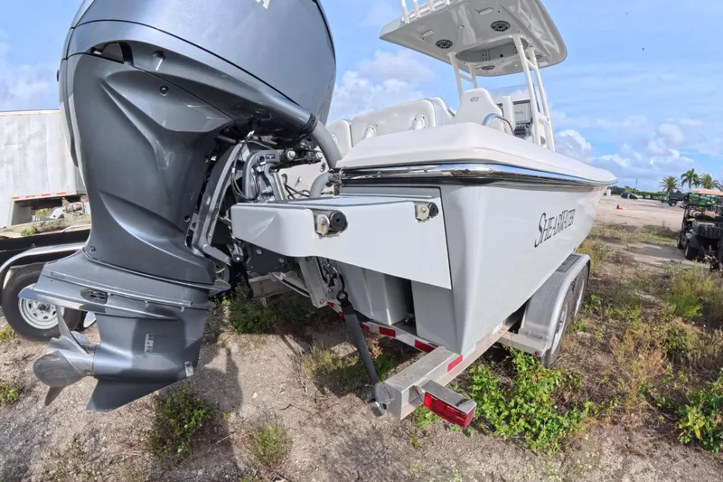 Slide: The Image of 2023 ShearWater 270 Carolina Flare boat on trailer, featuring powerful outboard motor. - 7