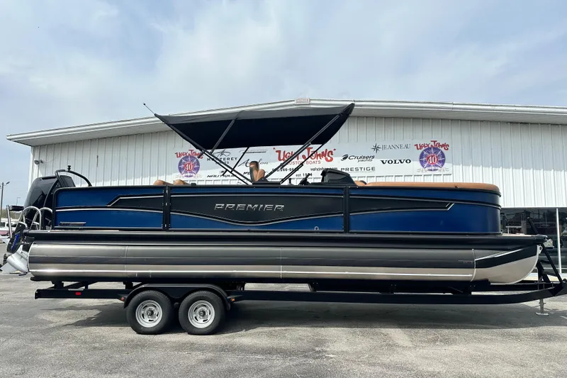 The Image of 2026 Premier 250 Intrigue RLO pontoon boat on trailer, parked outside dealership. - 1