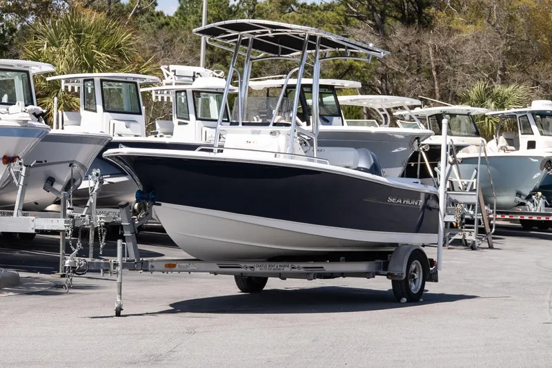 Slide: The Image of 2012 Sea Hunt Triton 188 boat on trailer, surrounded by other boats in a marina. - 2