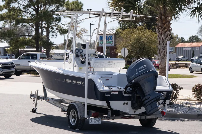 Slide: The Image of 2012 Sea Hunt Triton 188 boat on trailer with Yamaha outboard motor, parked outdoors. - 4