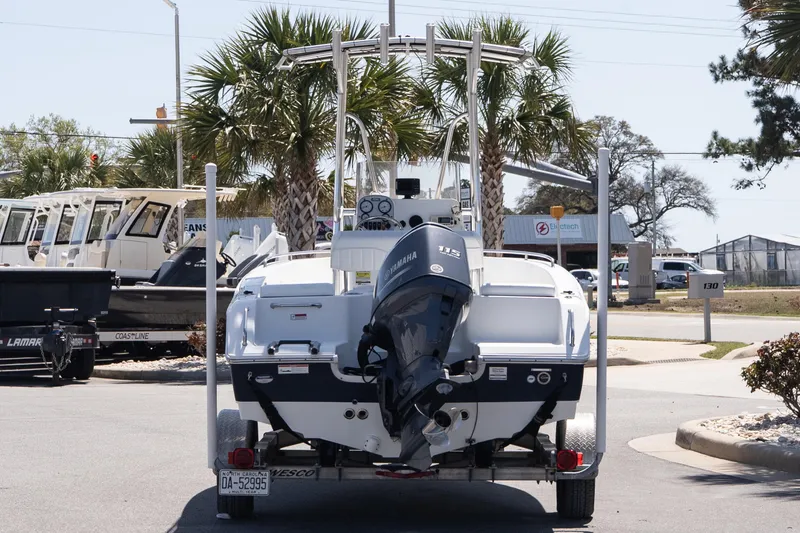 Slide: The Image of 2012 Sea Hunt Triton 188 boat on trailer, parked near palm trees. - 5