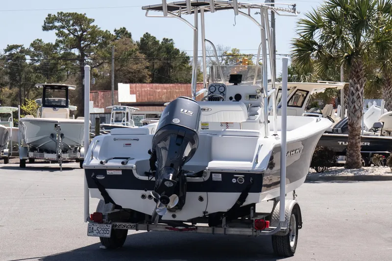 Slide: The Image of 2012 Sea Hunt Triton 188 boat on trailer, featuring Yamaha 115 engine, parked outdoors. - 6
