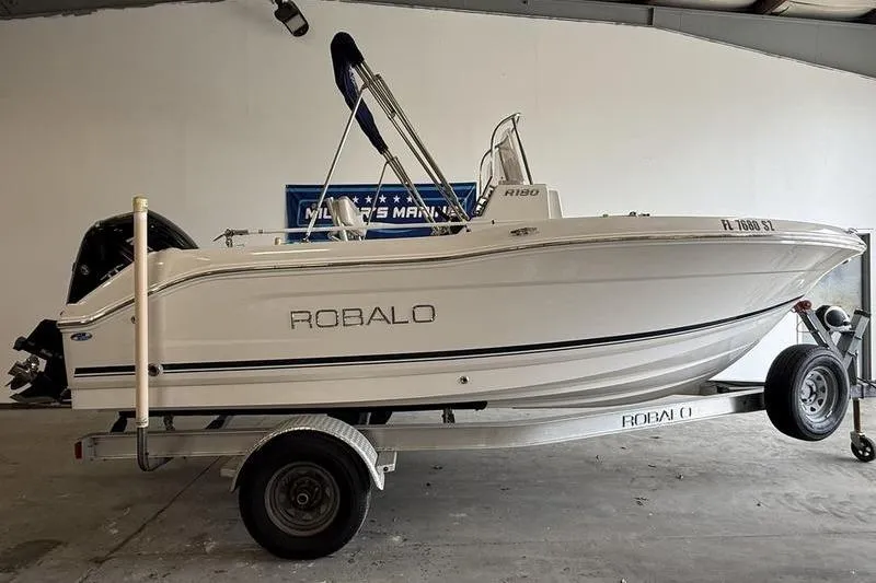 The Image of 2018 Robalo R180 Center Console boat on trailer in indoor storage. - 0