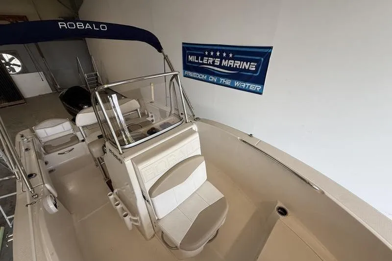 Slide: The Image of 2018 Robalo R180 Center Console boat in showroom, featuring Miller's Marine banner. - 12
