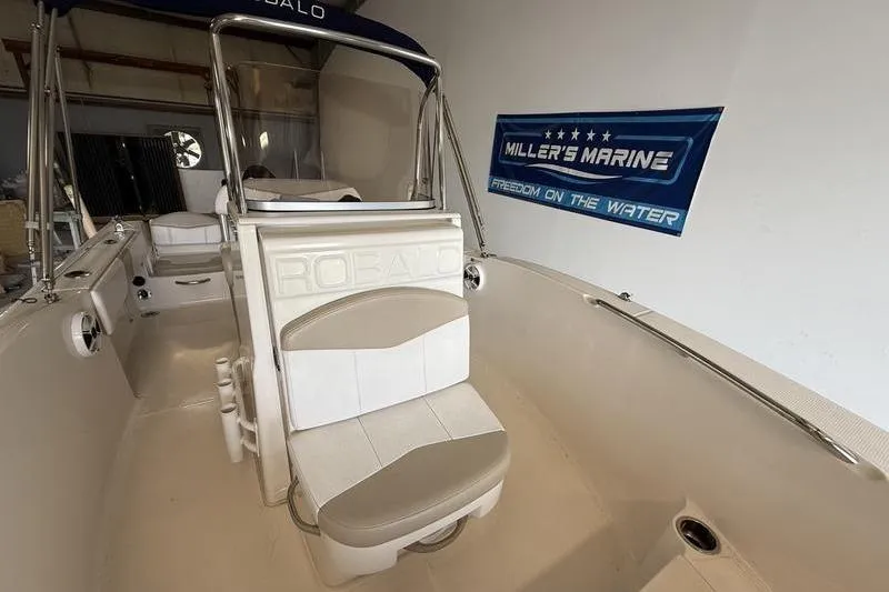 Slide: The Image of 2018 Robalo R180 Center Console boat interior with seating and Miller's Marine banner. - 13