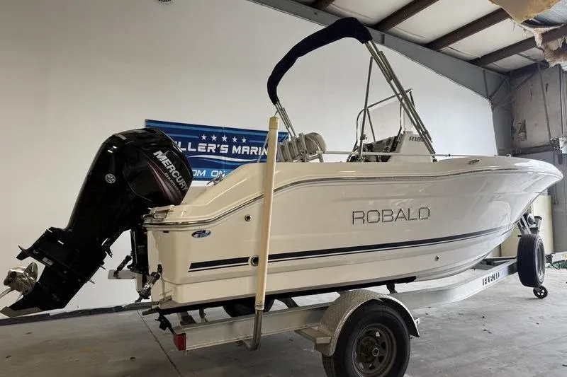 Slide: The Image of 2018 Robalo R180 Center Console boat on trailer in indoor storage. - 3