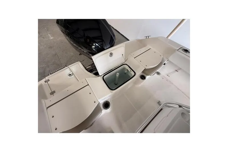 Slide: The Image of 2018 Robalo R180 Center Console boat interior with storage compartments and motor. - 4