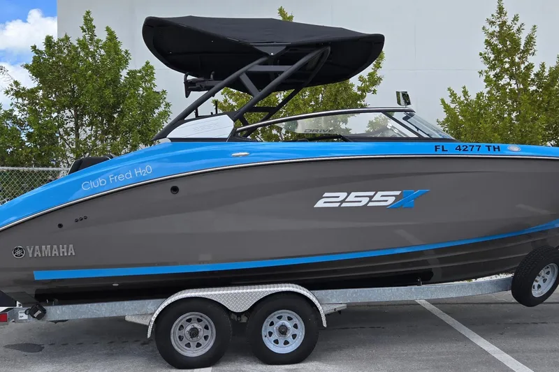 Slide: The Image of 2022 Yamaha Boats 255XD on trailer, featuring sleek design and vibrant blue accents. - 12