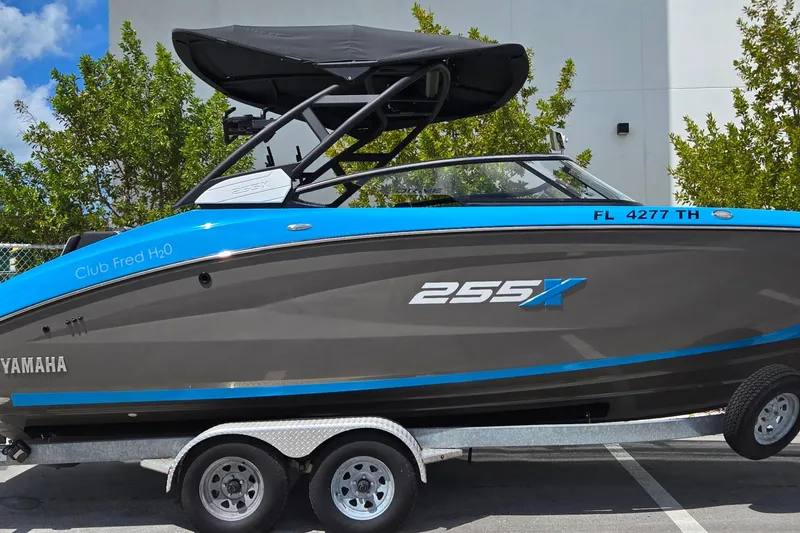 Slide: The Image of 2022 Yamaha Boats 255XD on trailer, blue and gray design, parked outdoors. - 14