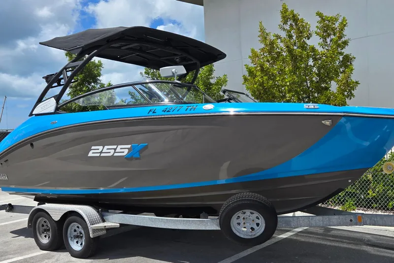 Slide: The Image of 2022 Yamaha Boats 255XD on trailer, blue and gray design, parked outdoors. - 15