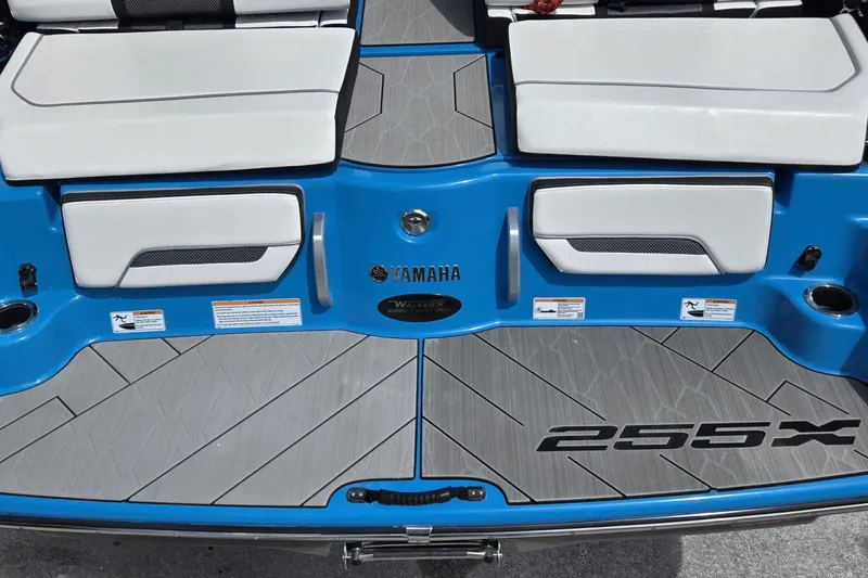 Slide: The Image of 2022 Yamaha Boats 255XD, blue and white deck with seating and branding. - 19