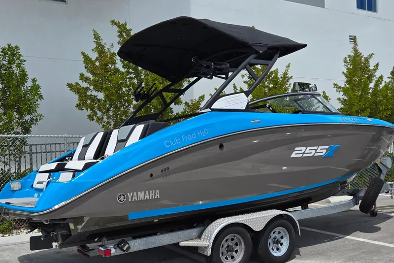 Slide: The Image of 2022 Yamaha Boats 255XD on trailer, blue and gray design, parked outdoors. - 3