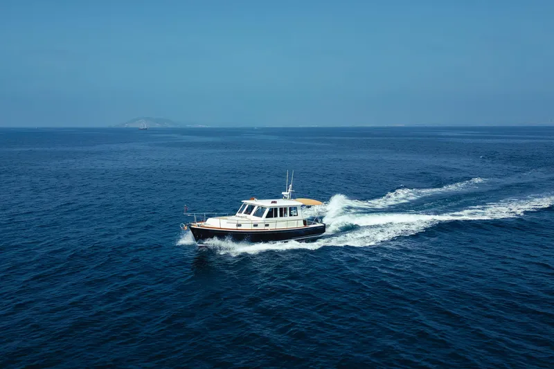 The Image of 1998 Grand Banks 43 Eastbay EX cruising on open blue sea. - 1