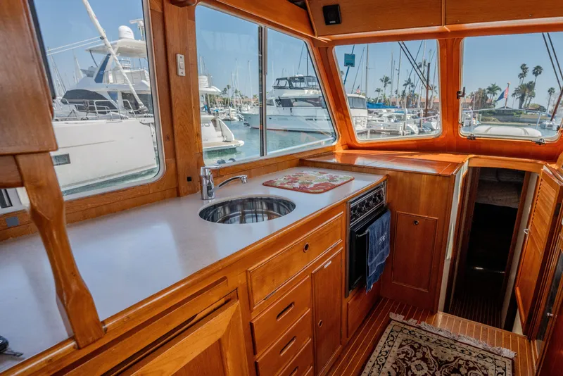 Slide: The Image of Interior of 1998 Grand Banks 43 Eastbay EX yacht with wooden cabinetry and marina view. - 10