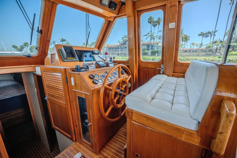 Slide: The Image of Interior of 1998 Grand Banks 43 Eastbay EX yacht with wooden helm and plush seating. - 13
