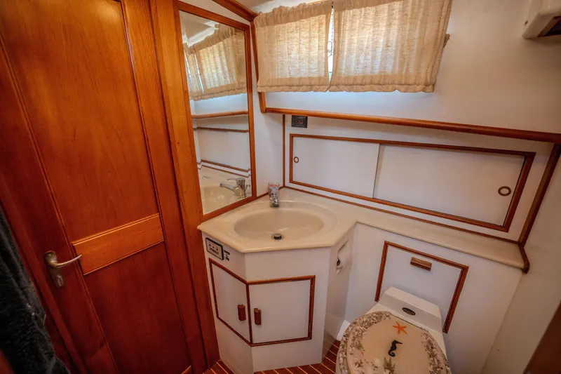 Slide: The Image of Bathroom interior of 1998 Grand Banks 43 Eastbay EX yacht, featuring wood accents and sink. - 20