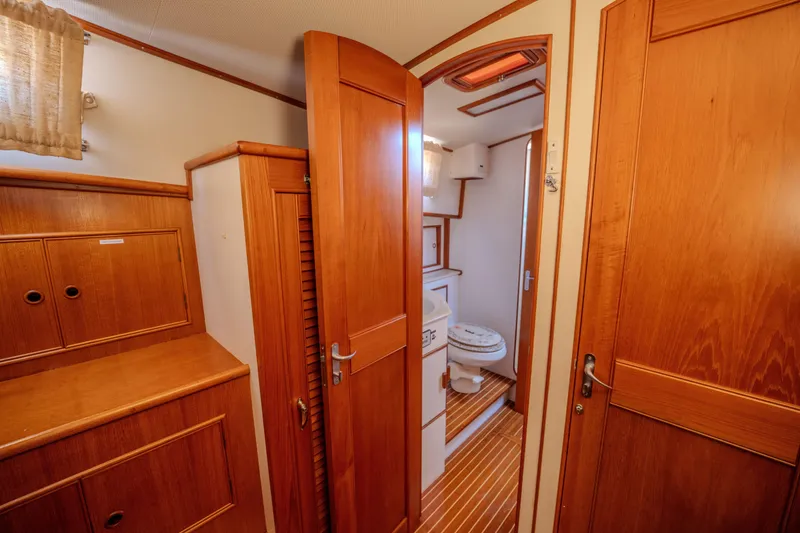 Slide: The Image of Interior of 1998 Grand Banks 43 Eastbay EX yacht, featuring wooden cabinetry and a compact bathroom. - 24