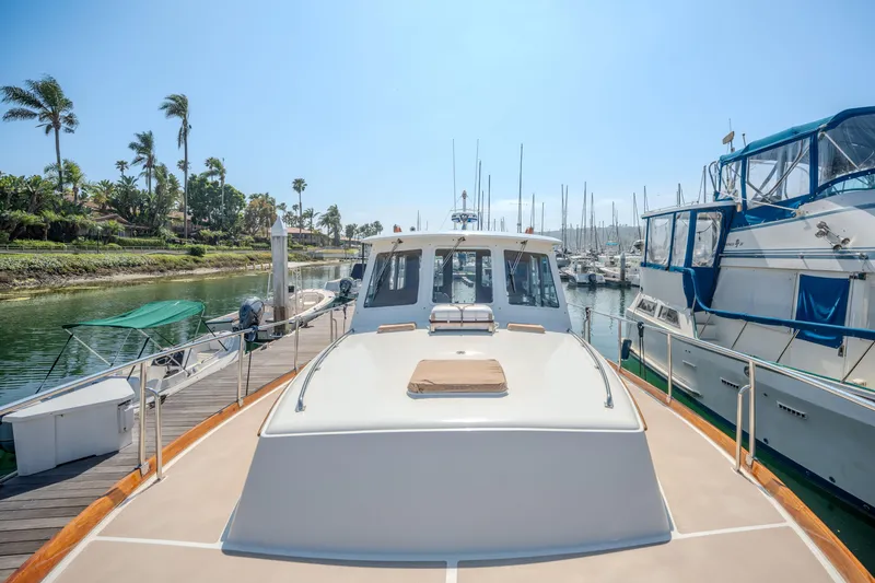 Slide: The Image of 1998 Grand Banks 43 Eastbay EX yacht docked in a sunny marina setting. - 28