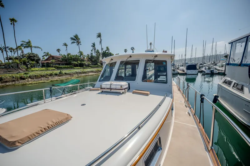 Slide: The Image of 1998 Grand Banks 43 Eastbay EX yacht docked in a marina, surrounded by palm trees. - 29