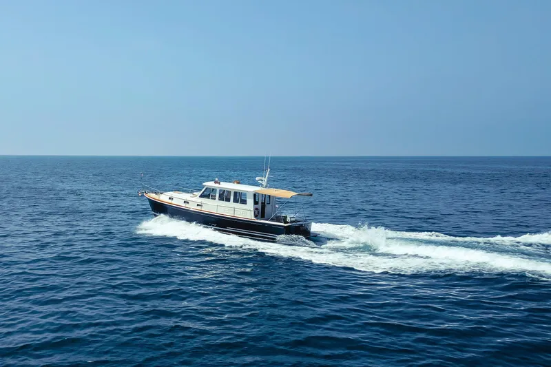 Slide: The Image of 1998 Grand Banks 43 Eastbay EX cruising on open blue sea. - 3