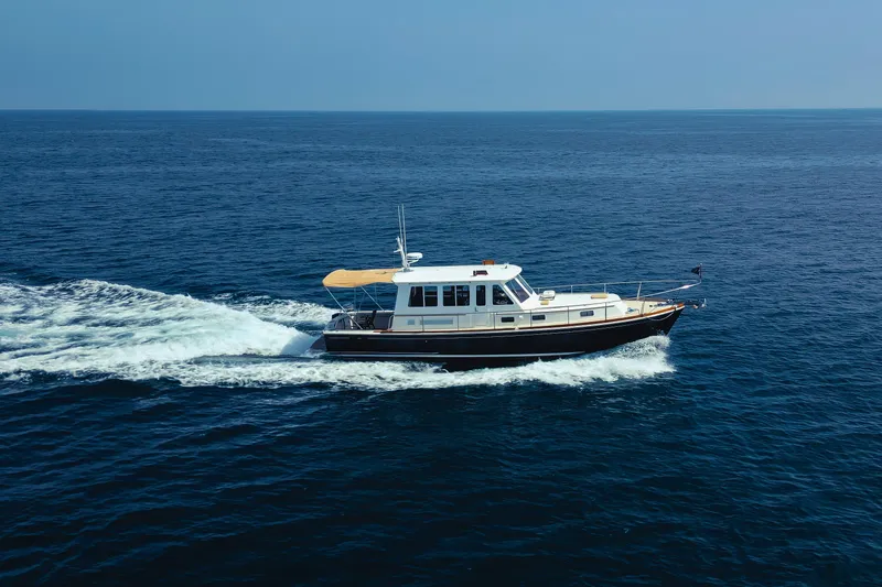 Slide: The Image of 1998 Grand Banks 43 Eastbay EX cruising on open sea under clear blue sky. - 6