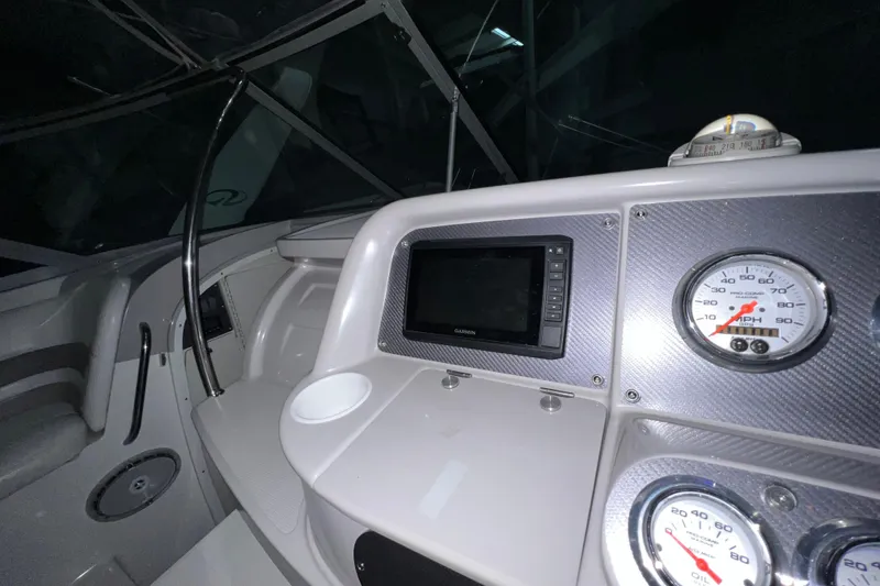 Slide: The Image of 1999 Formula 330 Sun Sport boat interior with steering wheel and Garmin navigation system. - 13
