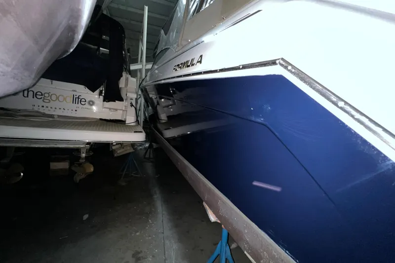 Slide: The Image of 1999 Formula 330 Sun Sport boat docked at marina under cloudy sky. - 2