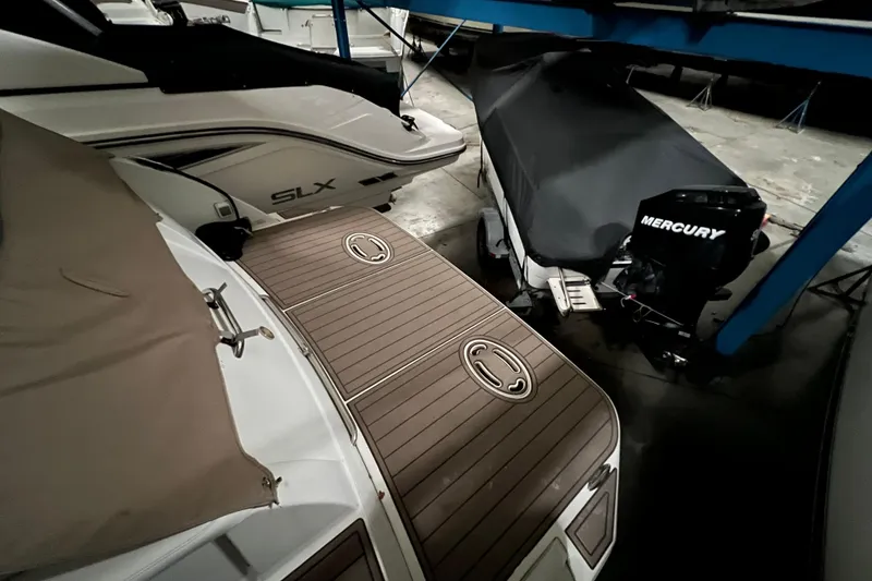 Slide: The Image of 1999 Formula 330 Sun Sport boat in storage, blue hull, adjacent to another vessel. - 4