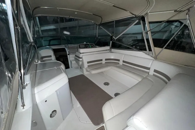 Slide: The Image of 1999 Formula 330 Sun Sport boat with beige canopy in storage. - 5