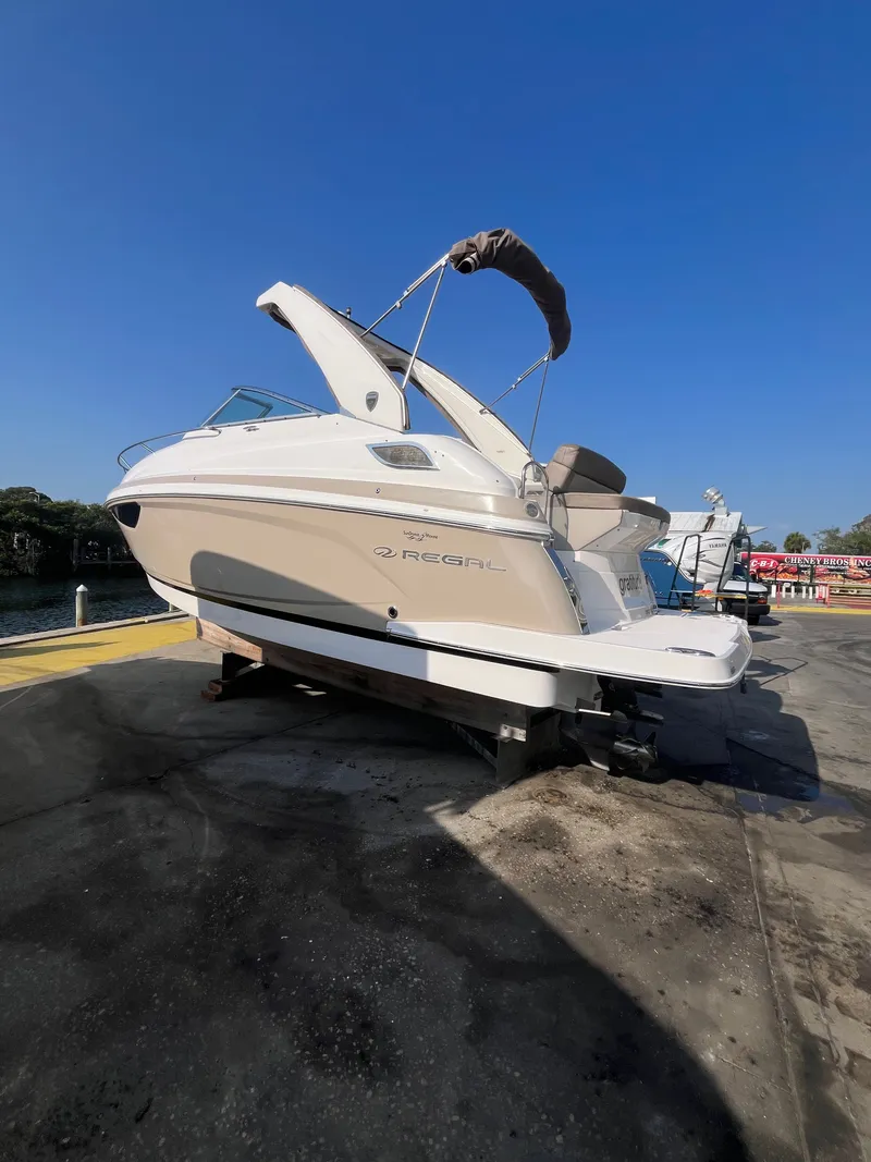 The Image of 2015 Regal 28 Express boat on a dock under clear blue sky. - 0